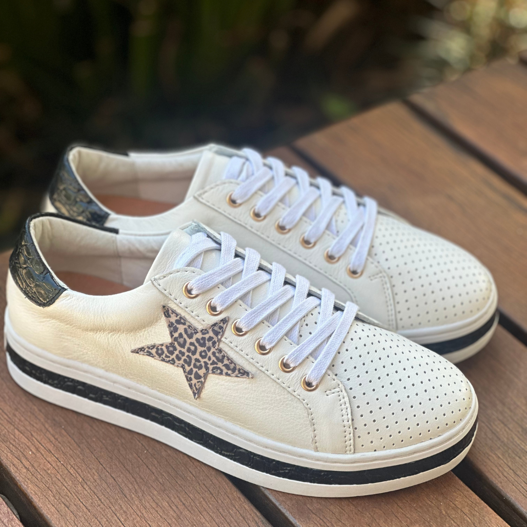 white sneakers with a leopard star and black trim on soles