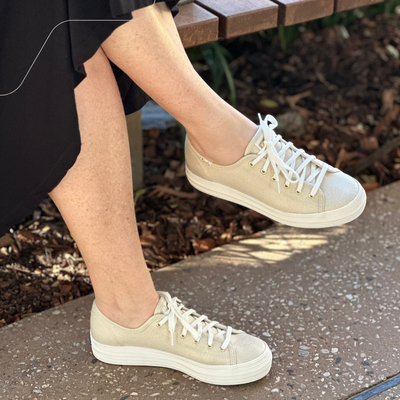 gold sneakers with white sole and white laces