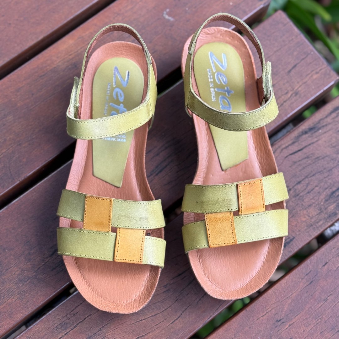 Pair of colorful sandals with 'Zeta' branding on a wooden surface