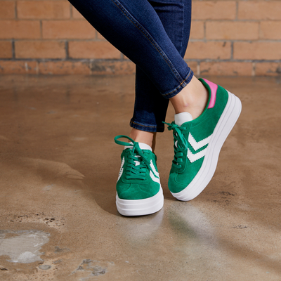 green platform sneakers with white sole and pink trim on heel