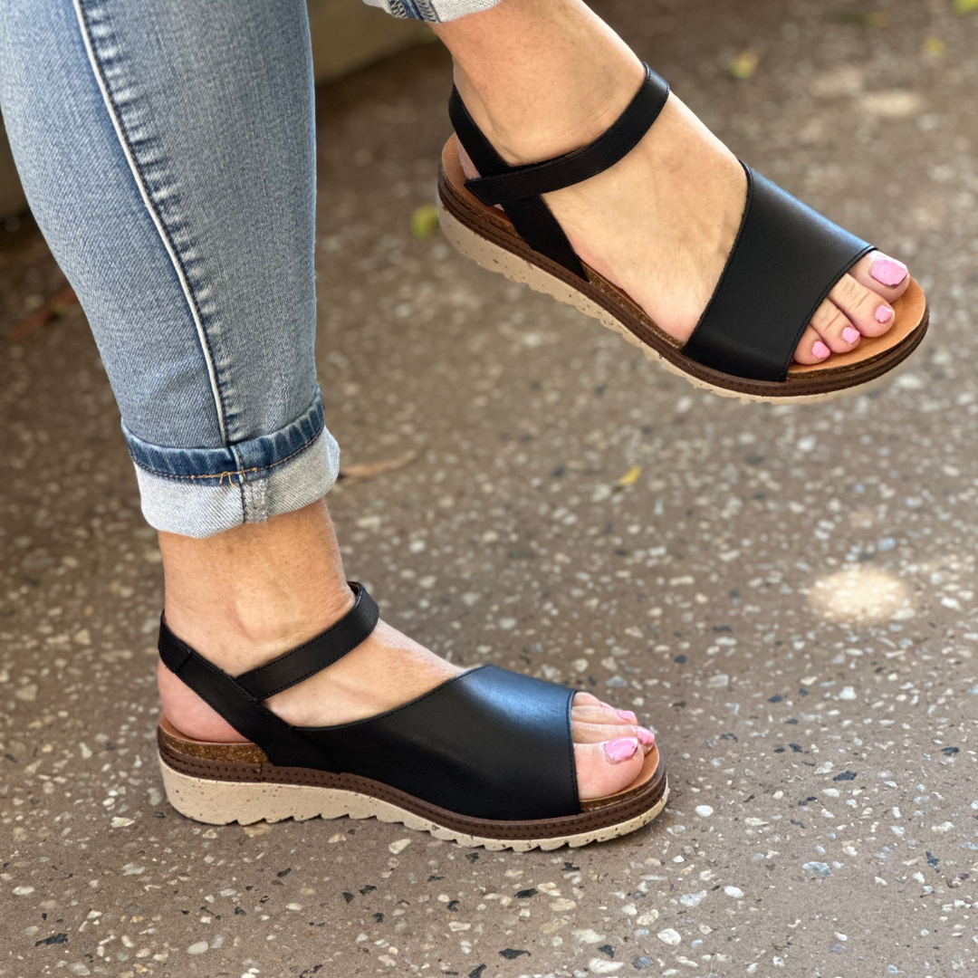 Black leather sandals on a low wedges