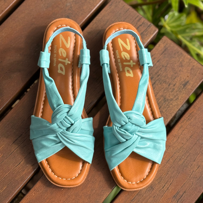 light blue tubed leather sandals with elastic black straps
