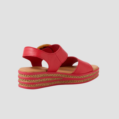 Red sandal with a  platform sole on a light grey background
