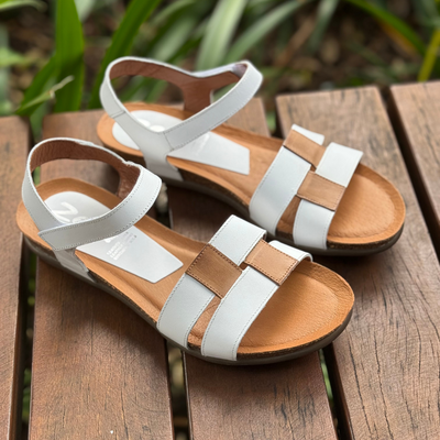 white flat sandals with beige details

