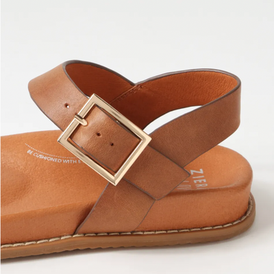 Tan sandal with a gold buckle on a white background