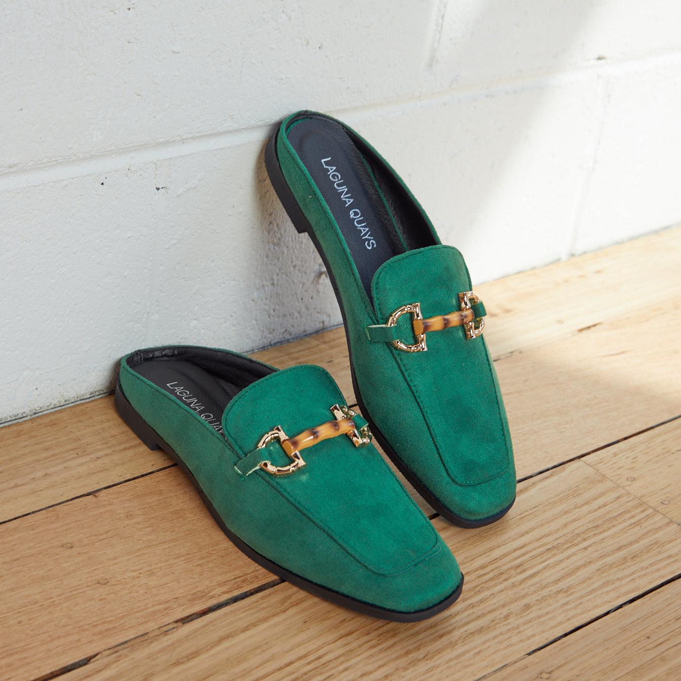 green mules with gold trim buckle